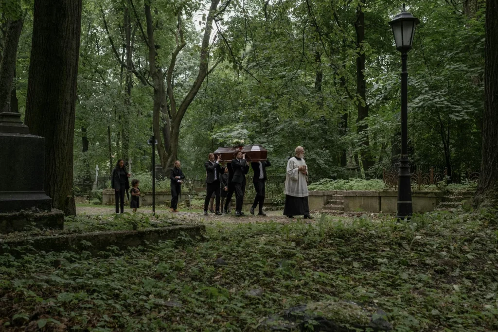 Family walking to a gravesite with flowers